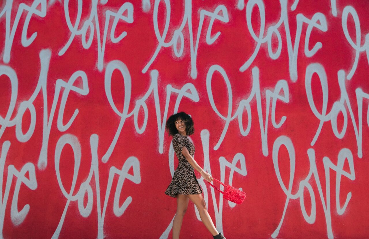 Woman in dress in front of Love graffiti wall