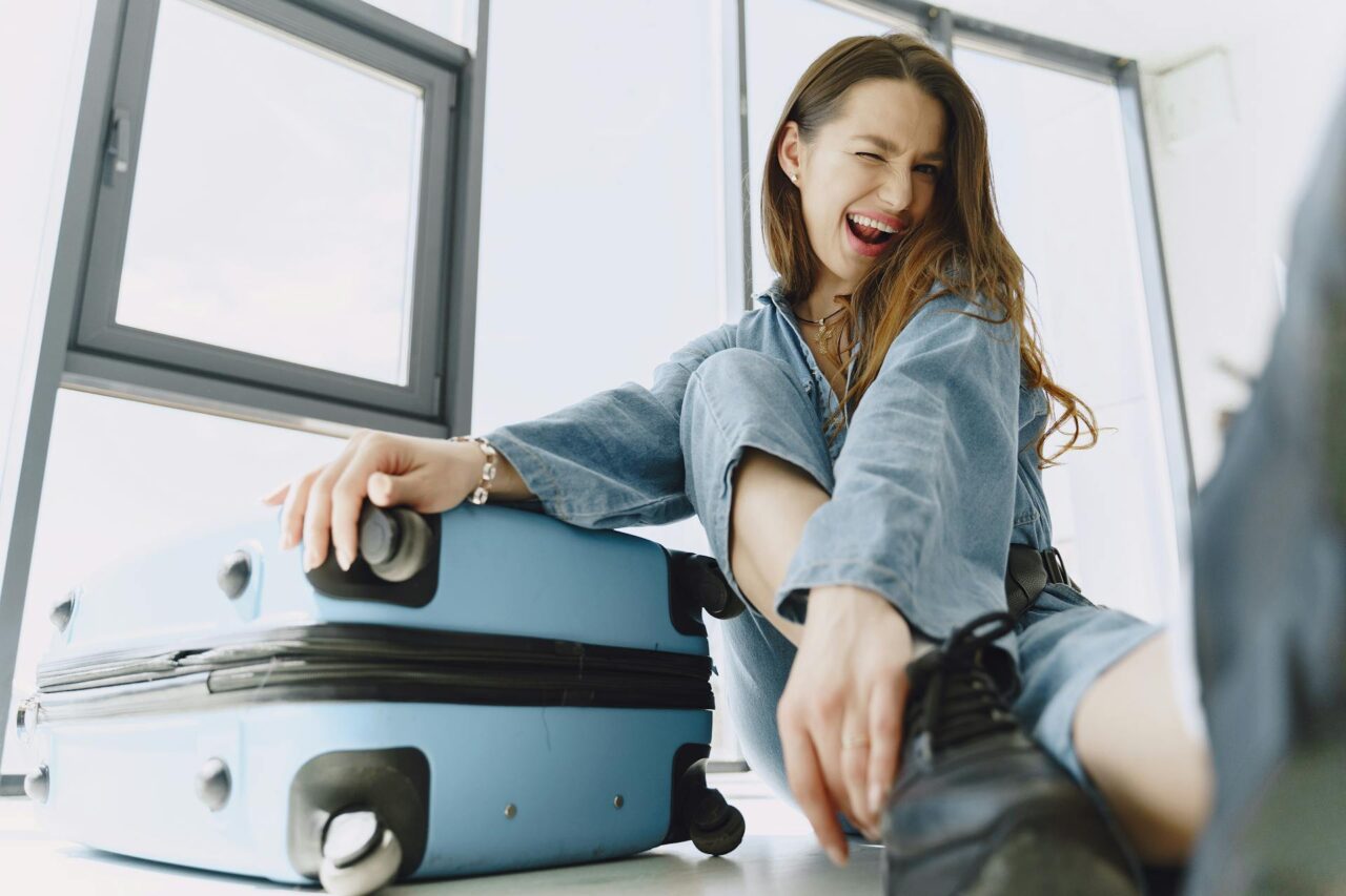 Woman sitting on floor with blue luggage