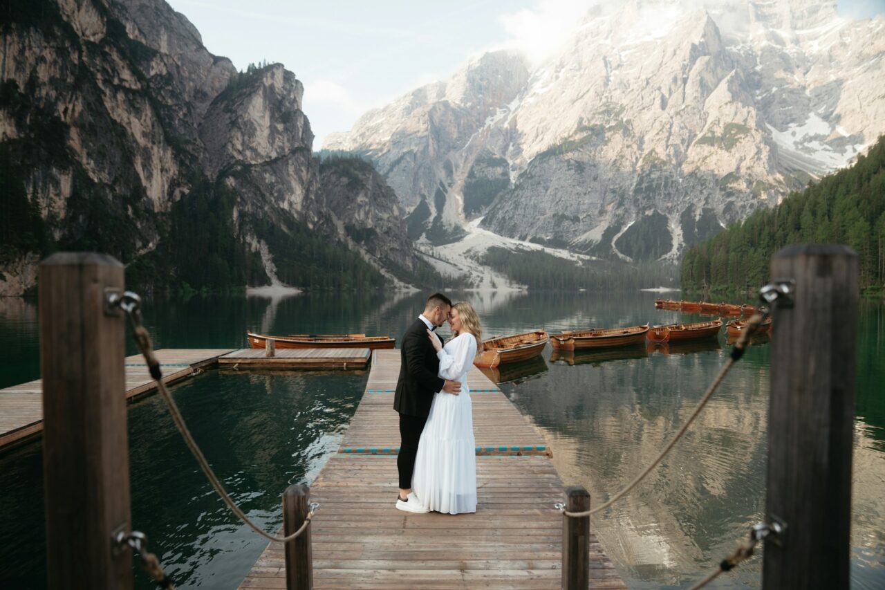 Bride and groom next to a lake in Italy with mountains