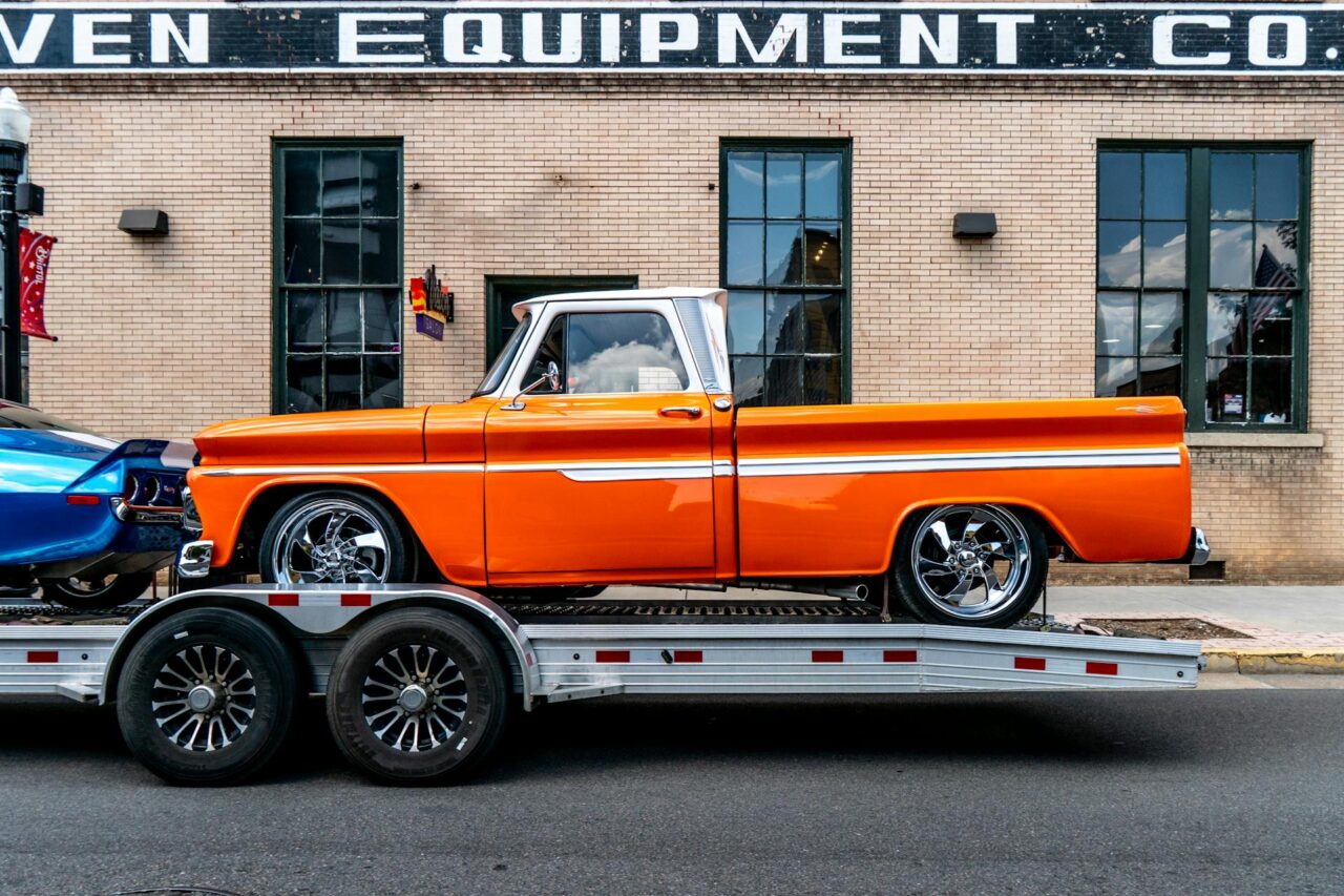 Orange pickup truck on a trailer