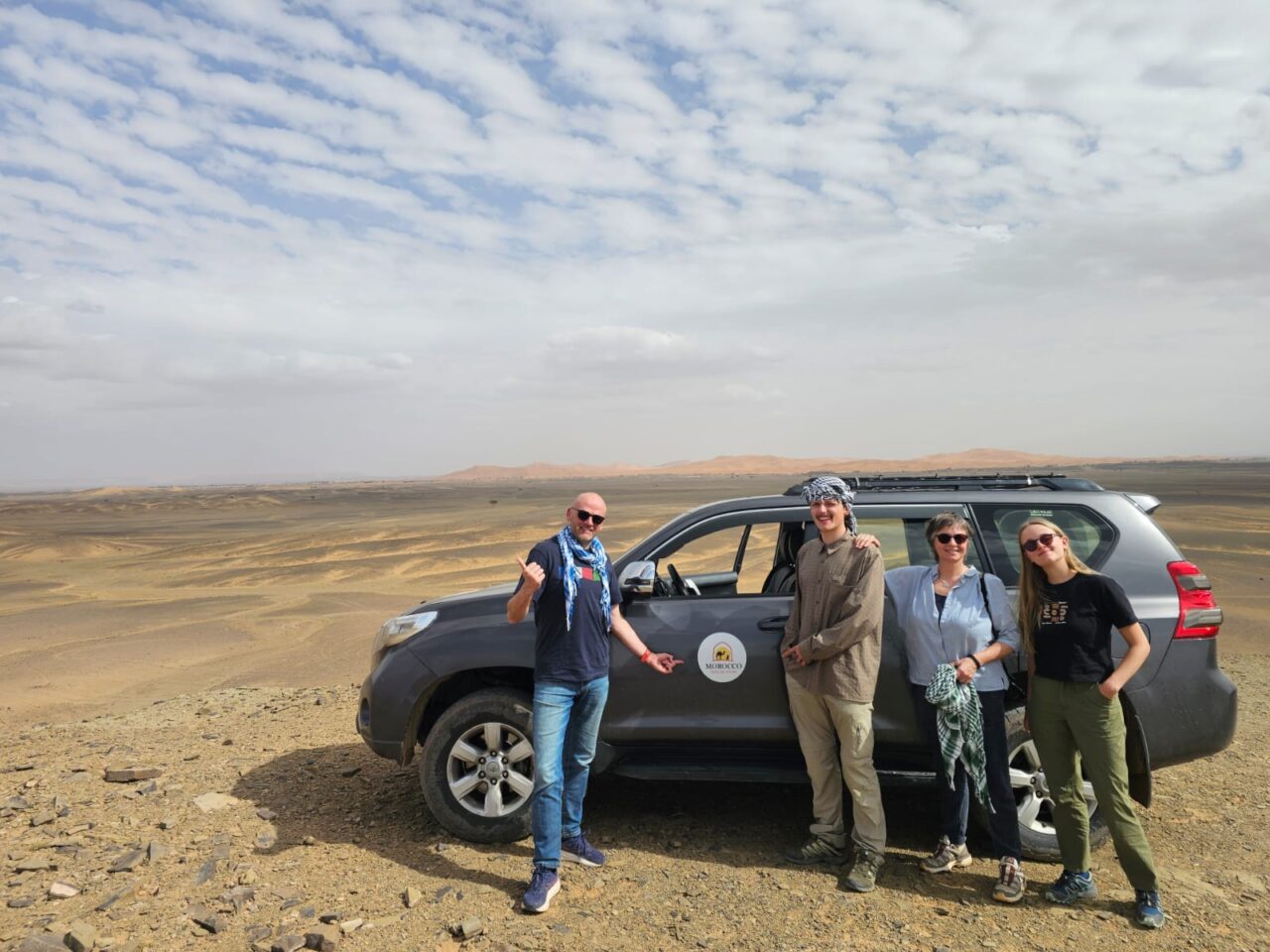 Tour group of people next to a car in Morocco