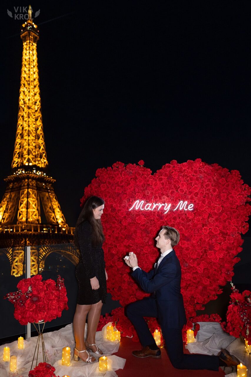 Man proposing to woman next to the Eiffel Tower at night