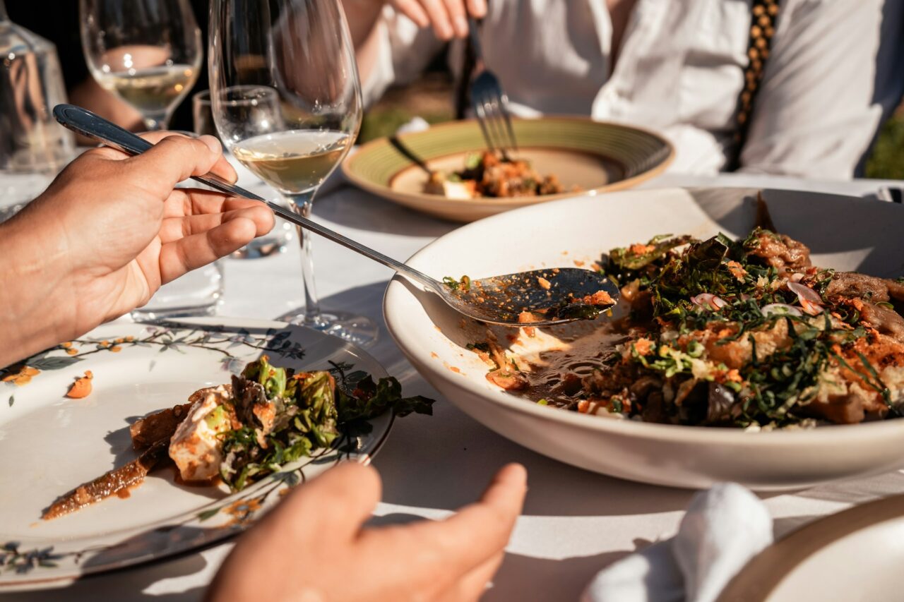 Close up of people helping themselves to food at a table