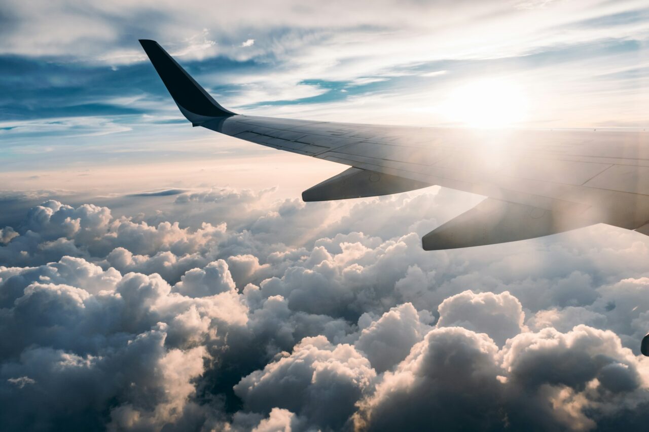 Plane wing flying over clouds