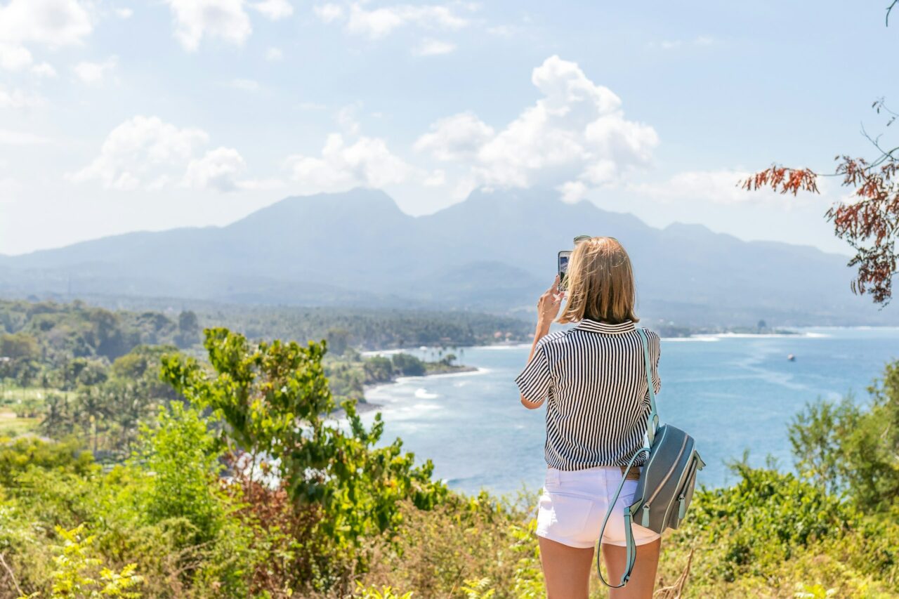 Woman taking a photo of the coastline and ocean