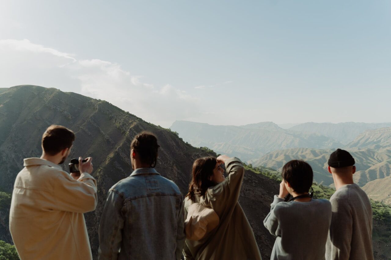 A group of friends observing a scenic mountain view.