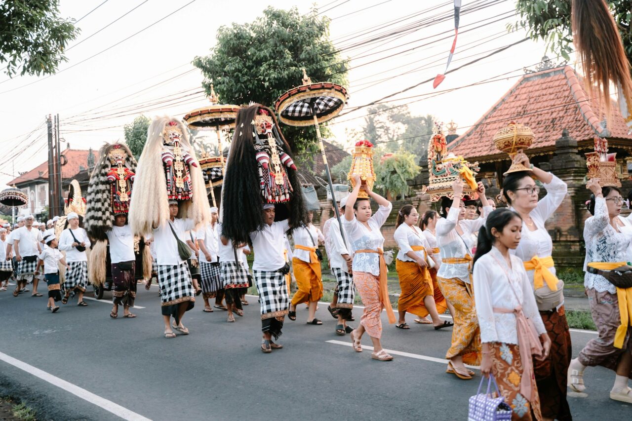 People parading down street during Melasti ceremony in Bali