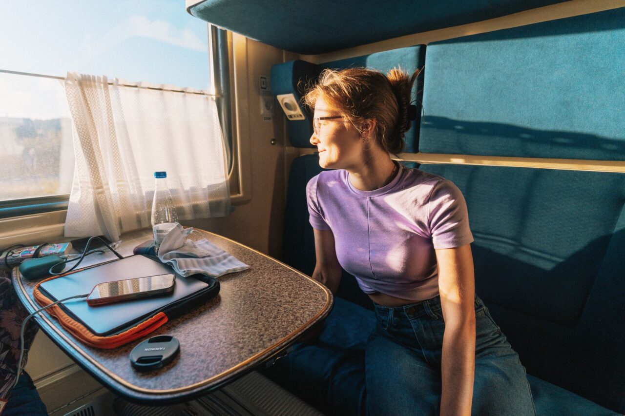 A woman gazes out of a train window.