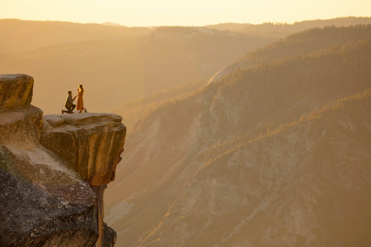 Man proposing to a woman on the top of a rock formation