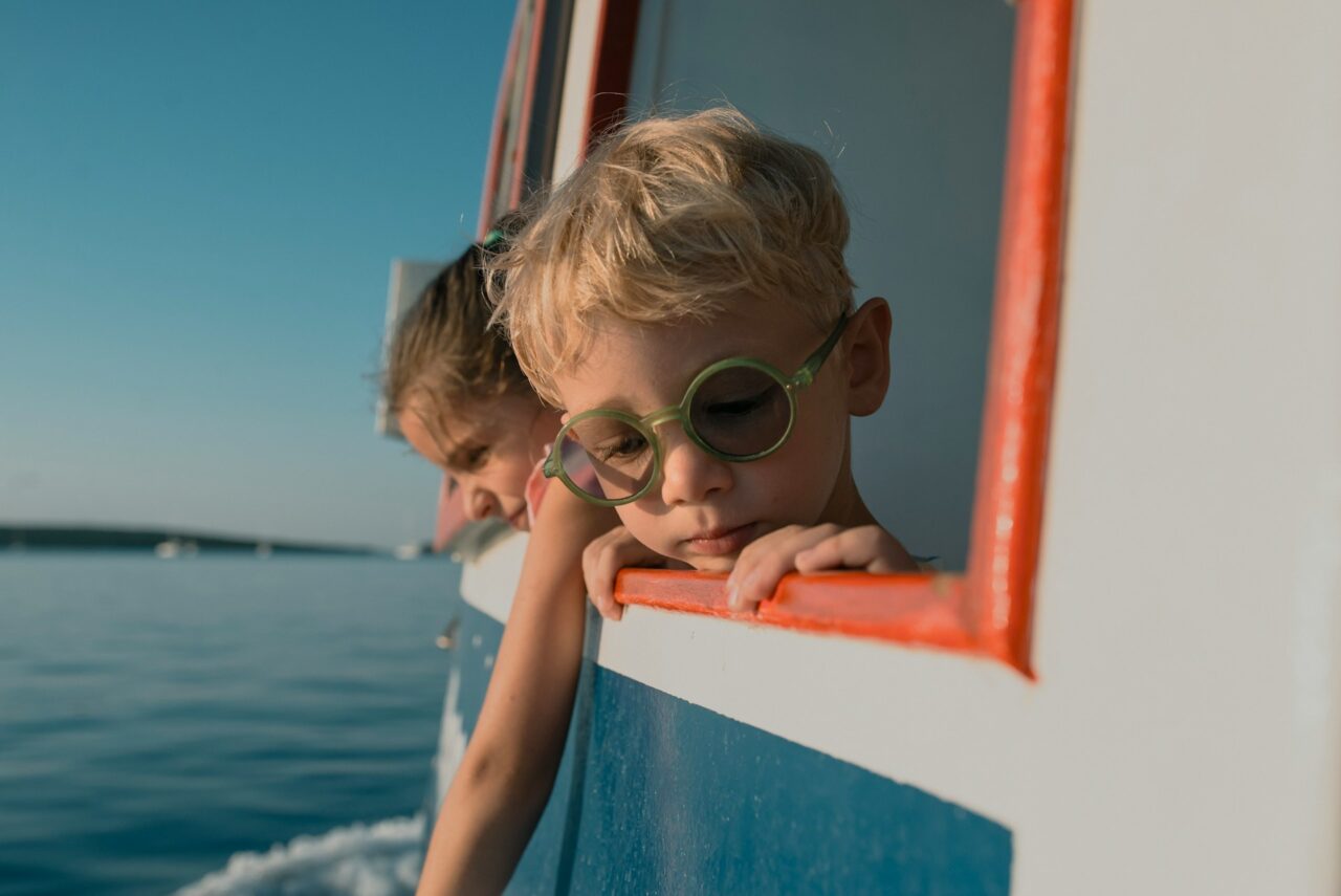 Two boys looking out of the window of a boat