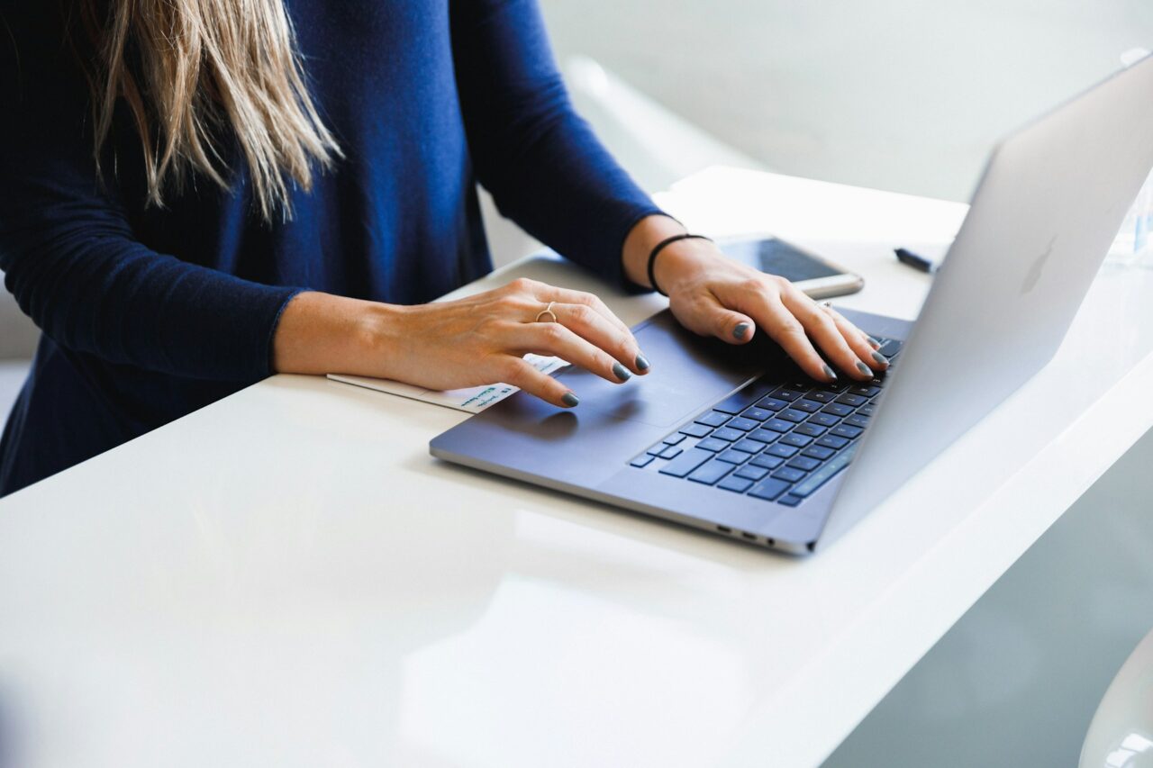 Woman sitting at a desk typing on laptop