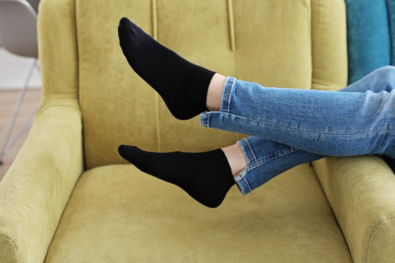 Woman's feet with black socks on a chair